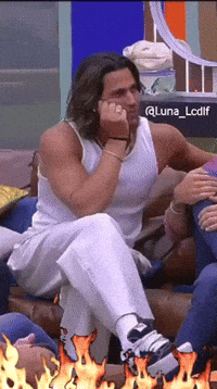 a man in a white tank top sits on a couch next to a sign that says @luna_lcdif