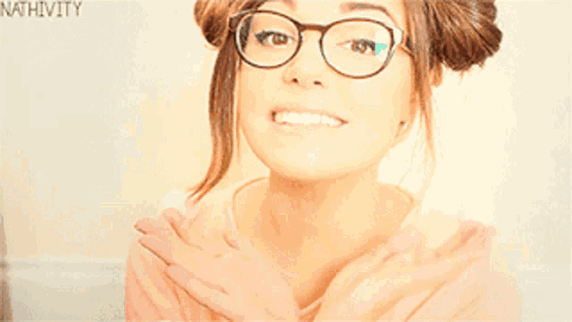 a woman wearing glasses and a pink shirt has the word nativity on the bottom