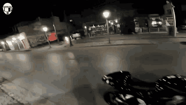a person riding a motorcycle down a street at night with a helmet on