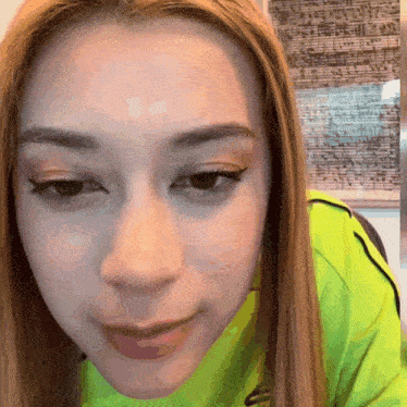 a close up of a woman 's face wearing a neon green shirt