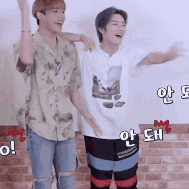 two young men are standing next to each other and laughing .