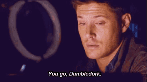 a man is sitting in front of a computer screen and saying `` you go , dumbledork . ''