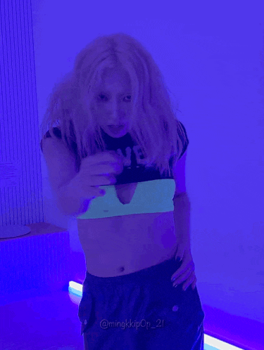 a woman in a neon crop top with the word never on it is dancing