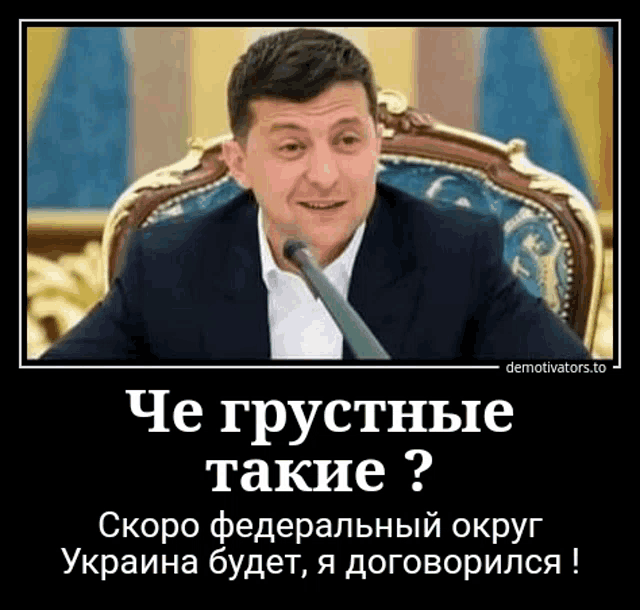 a man in a suit is sitting in a chair with a microphone in front of him and a caption in russian