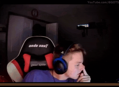 a man wearing headphones is sitting in an ande seat gaming chair