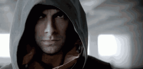 a man in a hooded jacket looks at the camera .