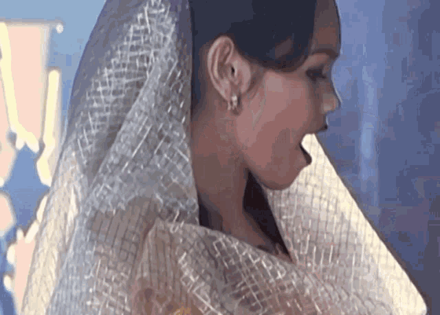 a close up of a woman wearing a white veil and earrings