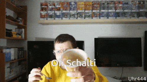 a man in a yellow sweater is holding a cup of soup with the words oh schalti written on it