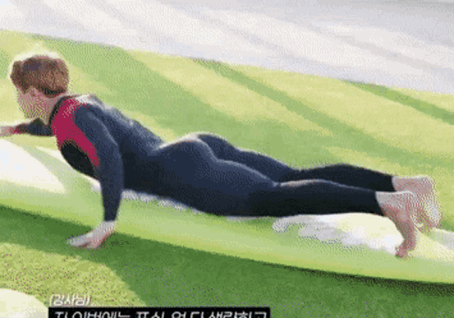 a person in a wetsuit is laying on a surfboard