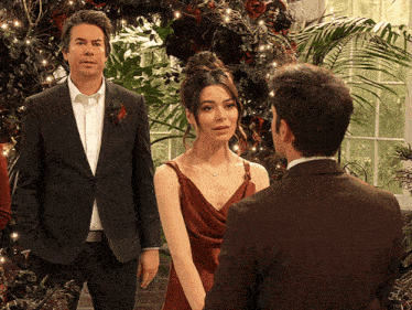 a man in a suit and a woman in a dress are standing next to each other