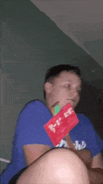 a boy in a blue shirt is holding a piece of paper that says b-f-ck on it