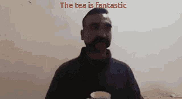 a man with a mustache is holding a cup of tea with the words the tea is fantastic behind him
