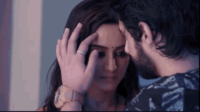 a man and a woman are touching each other 's foreheads .