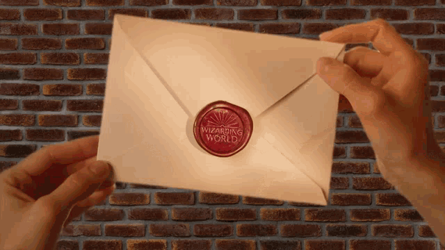 a person is holding an envelope with a wax seal that says wizarding world on it