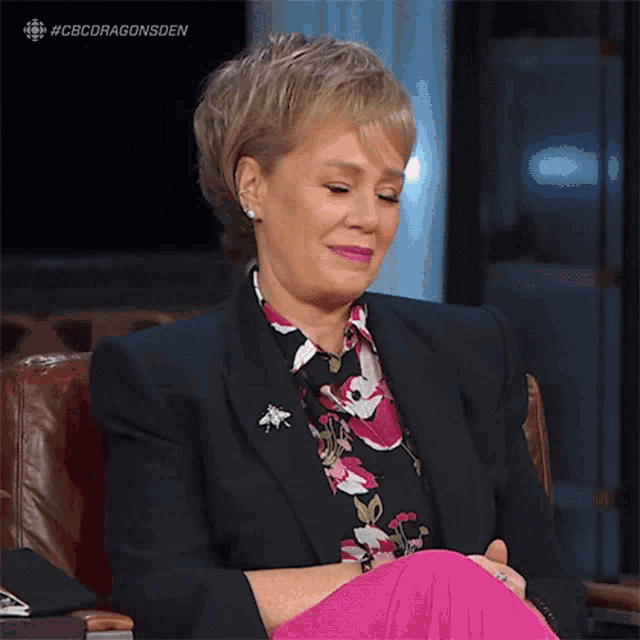 a woman is sitting in a chair with her legs crossed and the hashtag #cbcdragonsden is visible above her
