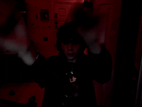 a person in a dark room with a sticker on the wall that says ' hot dog '