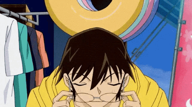 a man in a yellow shirt is wearing glasses and looking down