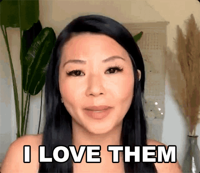 a woman is saying i love them in front of a plant .