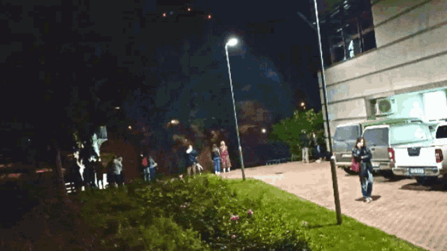 a group of people standing outside a building at night