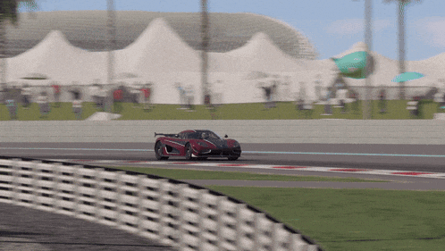 a red sports car is driving down a track
