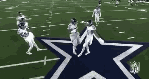 a group of football players are dancing on a field with a star in the background .