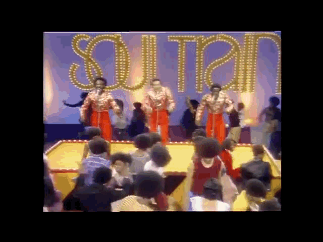 a group of people are dancing in front of a sign that says " sultan "