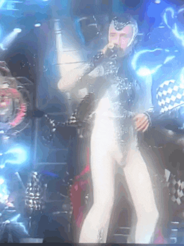 a man is singing into a microphone on a stage