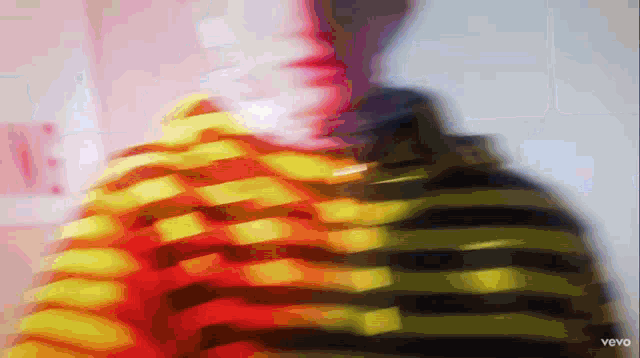 a blurry image of a person wearing a striped shirt