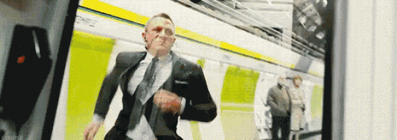 a man in a suit and tie is running on a subway .