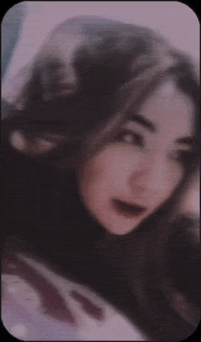 a blurry picture of a girl 's face with a pink background
