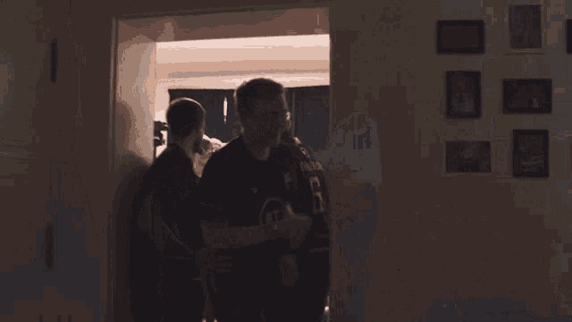 a group of men are hugging in a dark room