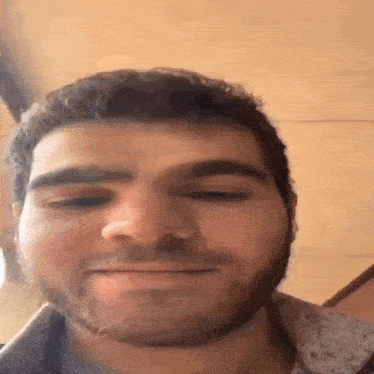 a man with a beard is smiling for the camera