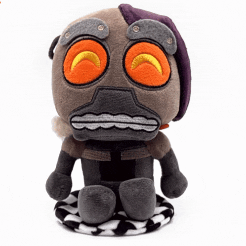 a stuffed toy that looks like a robot with orange eyes and a purple hat