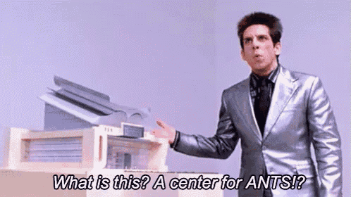 a man in a silver suit is standing in front of a printer .