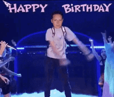 a man in a white shirt is standing in front of a sign that says birthday