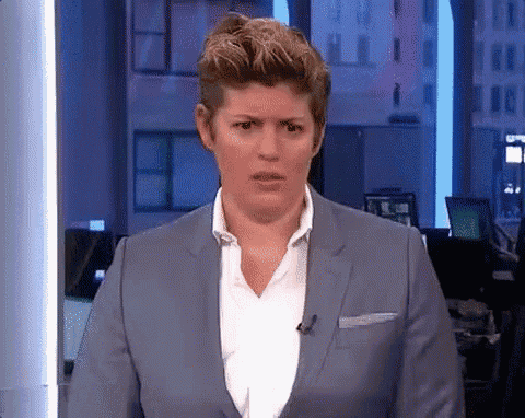 a woman in a blue suit and white shirt is making a funny face .