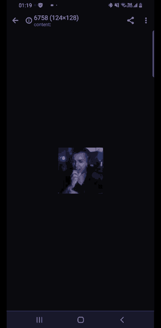 a phone screen shows a picture of a man in a dark room