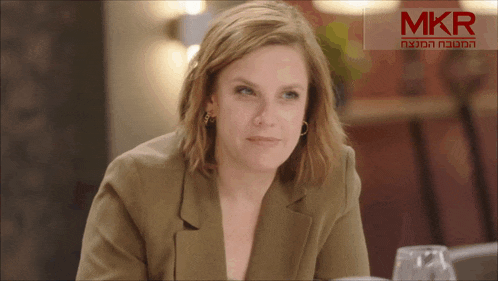 a woman is sitting in front of a mkr sign