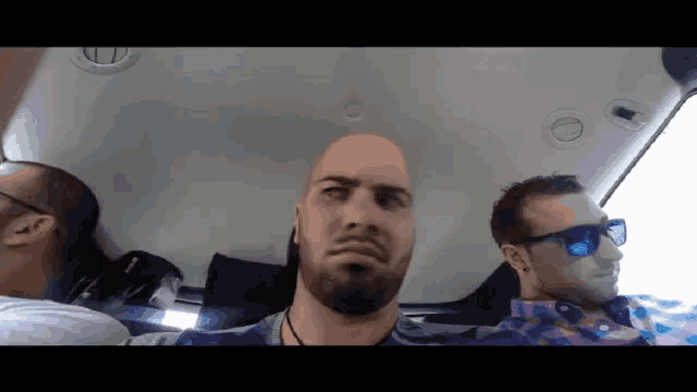 a man with a beard is wearing sunglasses and making a face
