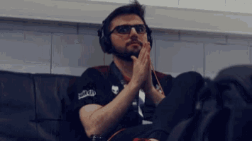 a man wearing headphones and a shirt that says twitch is sitting on a couch