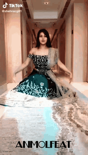 a woman in a dress is dancing in a hallway with the words anmolfeat written on the bottom