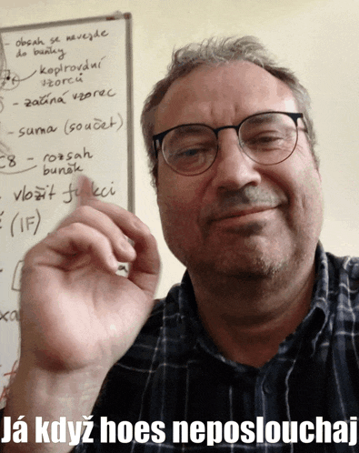 a man wearing glasses is smiling in front of a whiteboard that says " ja kdyz hoes nepostlouchaj "