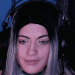a woman wearing headphones and a wig is smiling .