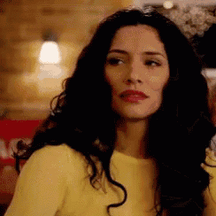 the woman is wearing a yellow sweater and red lipstick .