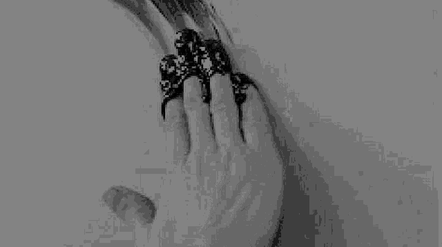 a black and white photo of a person 's hand holding a bottle of liquid .