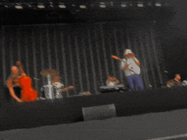 a man playing a guitar and a woman playing a violin are on stage