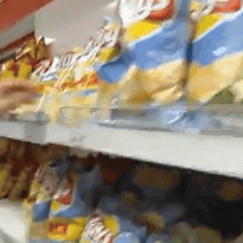 a person is reaching for a bag of potato chips