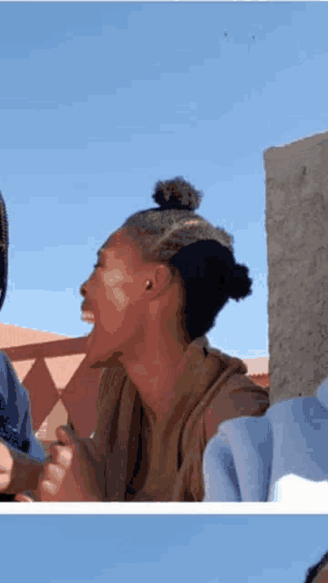 a woman with a bun on her head is laughing with another woman