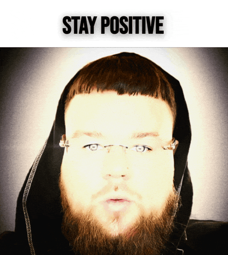 a man with a beard wearing glasses and a hoodie with the words stay positive above him