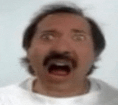 a man with a mustache is making a funny face with his mouth wide open .